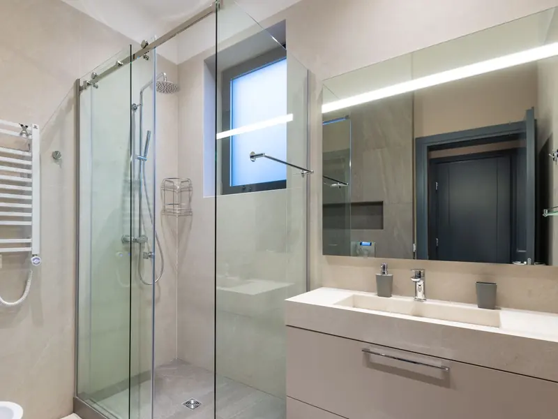The bathroom after the refit, with a walk-in shower and fresh tiles.